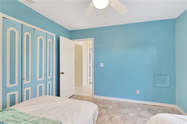 bedroom featuring ceiling fan, light tile patterned flooring, and a closet