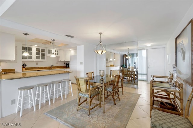 dining room with ceiling fan, sink, and light tile patterned floors