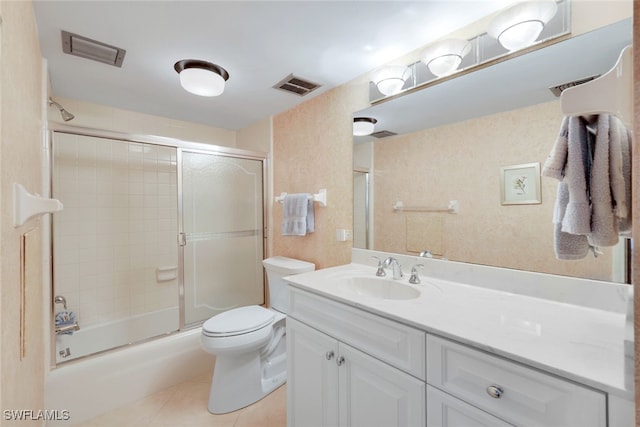 full bathroom with tile patterned floors, vanity, toilet, and bath / shower combo with glass door