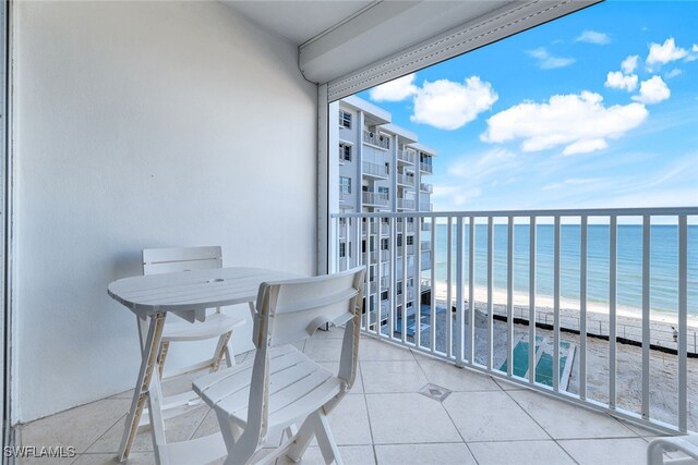 balcony featuring a water view and a view of the beach