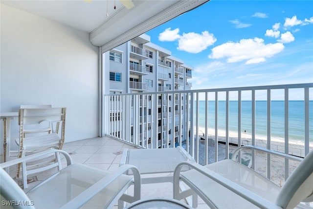 balcony featuring a beach view and a water view