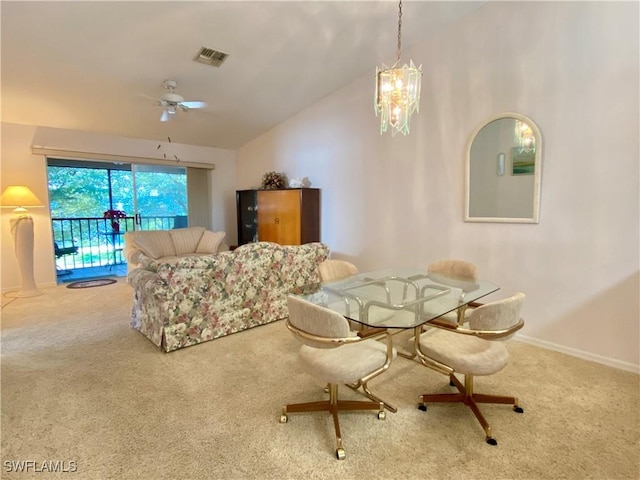 dining area featuring lofted ceiling, ceiling fan with notable chandelier, and carpet