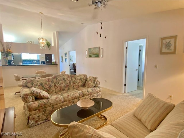 living room featuring a chandelier, vaulted ceiling, and light carpet