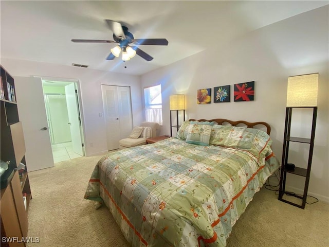 bedroom with ceiling fan, light colored carpet, and a closet