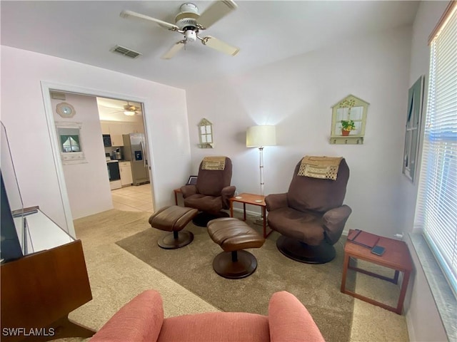 sitting room featuring light colored carpet and ceiling fan