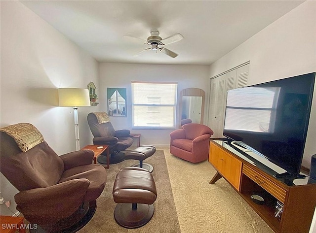 living area with light colored carpet and ceiling fan