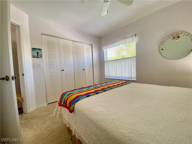 bedroom with ceiling fan, light carpet, and a closet