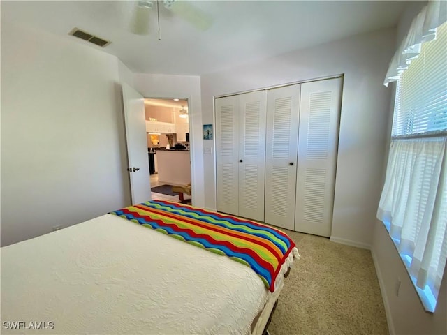 carpeted bedroom featuring ceiling fan and a closet