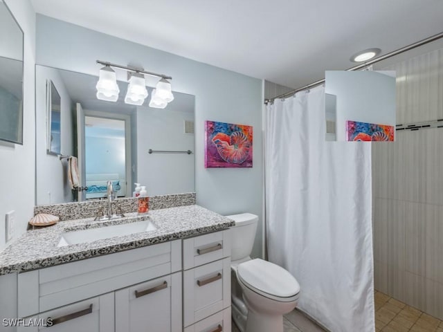 bathroom with walk in shower, vanity, and toilet