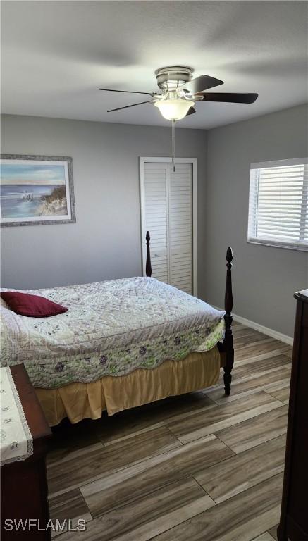 bedroom featuring hardwood / wood-style floors, a closet, and ceiling fan