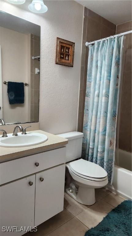 full bathroom with vanity, tile patterned floors, shower / bath combination with curtain, and toilet