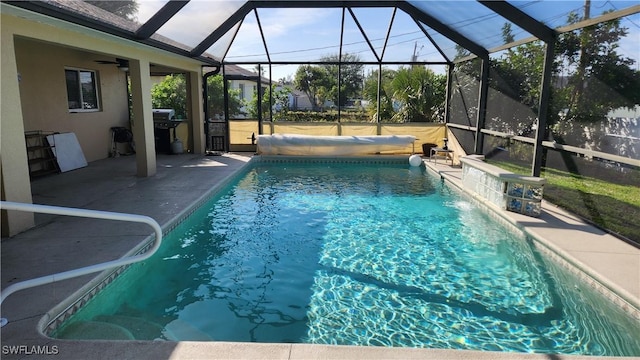 view of pool with a patio area, pool water feature, and glass enclosure