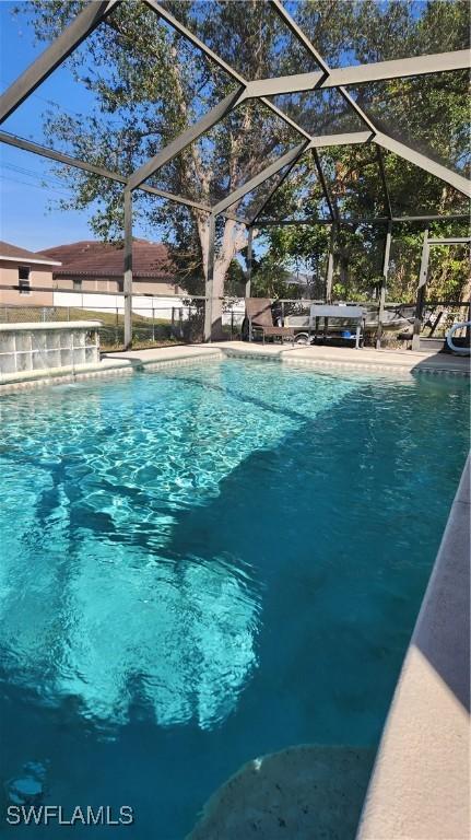 view of pool featuring glass enclosure and pool water feature