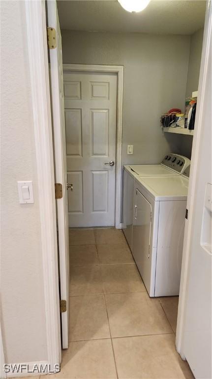 washroom with light tile patterned floors and separate washer and dryer