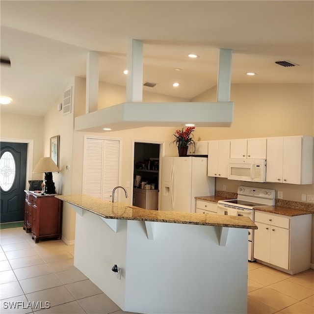 kitchen with a kitchen breakfast bar, white cabinets, white appliances, a kitchen island with sink, and light tile patterned floors