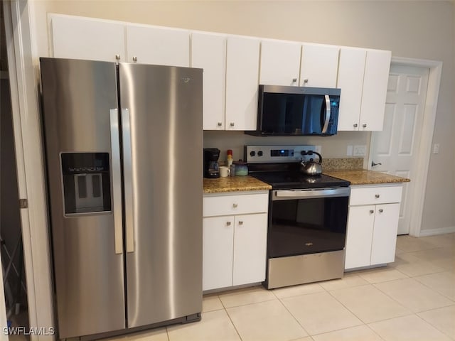 kitchen featuring white cabinetry, light tile patterned floors, stone counters, and appliances with stainless steel finishes