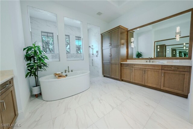 full bathroom with marble finish floor, a marble finish shower, a freestanding tub, and vanity