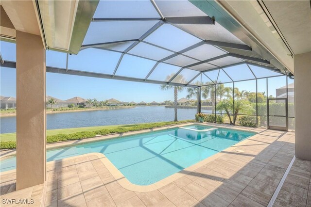 view of pool featuring glass enclosure, a water view, and a patio