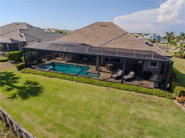 view of pool featuring a lanai, a pool with connected hot tub, a lawn, and a patio