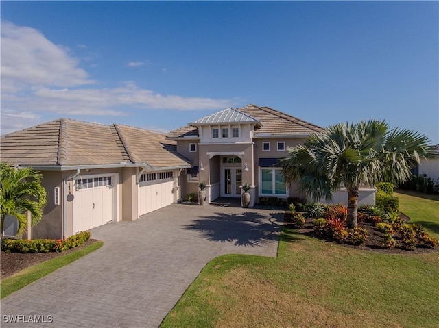 view of front of home with french doors, a front yard, and a garage