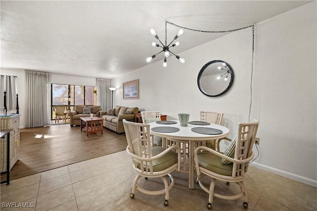 dining area with light tile patterned flooring and an inviting chandelier