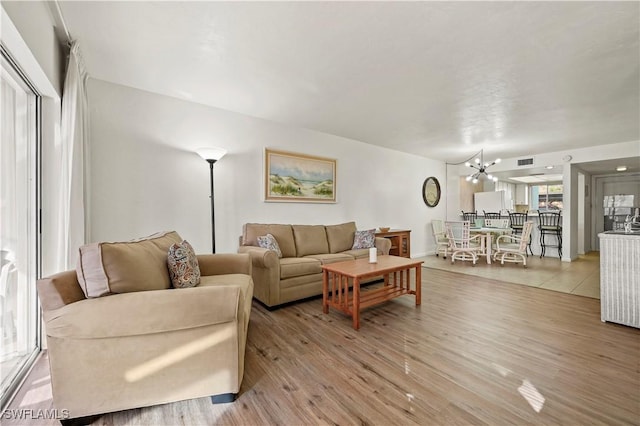 living room with light hardwood / wood-style flooring and a notable chandelier