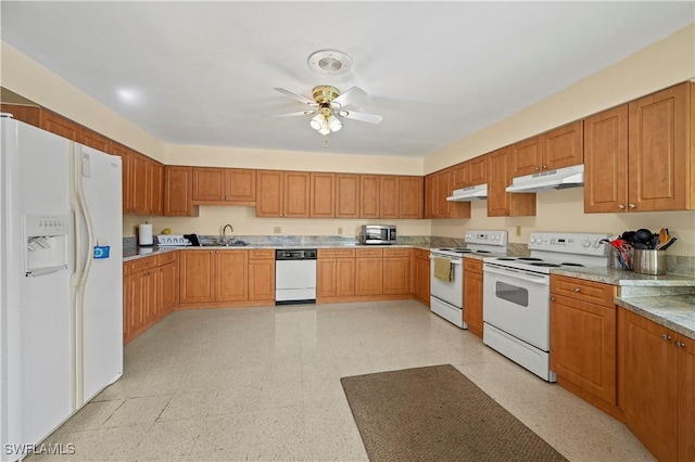 kitchen featuring light stone countertops, white appliances, ceiling fan, and sink