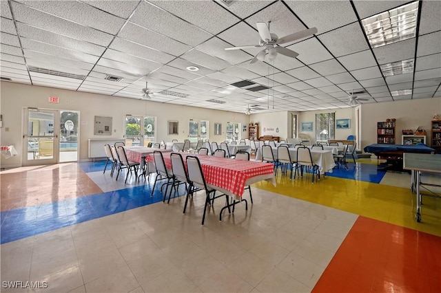 dining space with ceiling fan and a drop ceiling