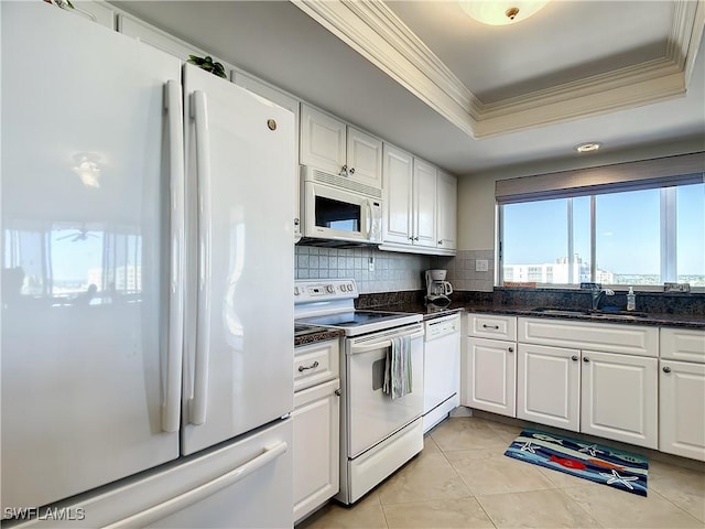 kitchen featuring a raised ceiling, white cabinets, white appliances, decorative backsplash, and light tile patterned floors