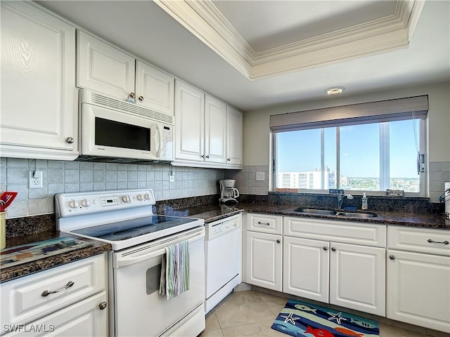 kitchen with white appliances, crown molding, sink, a tray ceiling, and white cabinetry