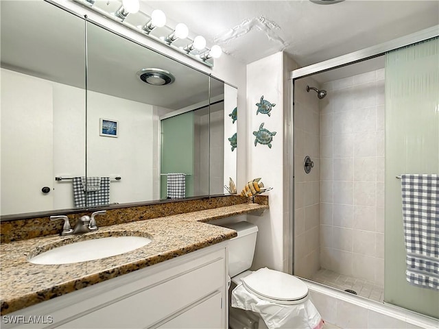 bathroom featuring toilet, vanity, and walk in shower