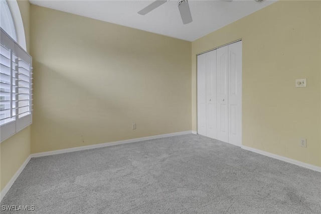 unfurnished bedroom with ceiling fan, a closet, and carpet flooring