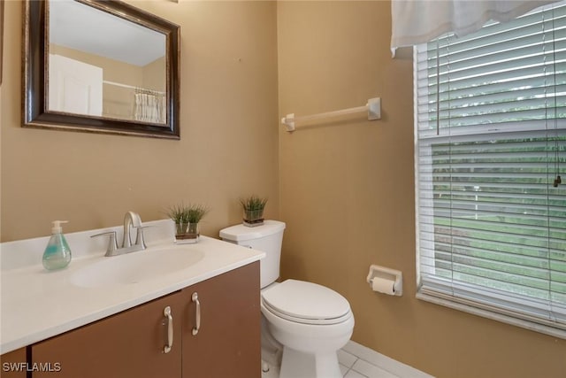 bathroom featuring toilet, vanity, and tile patterned flooring