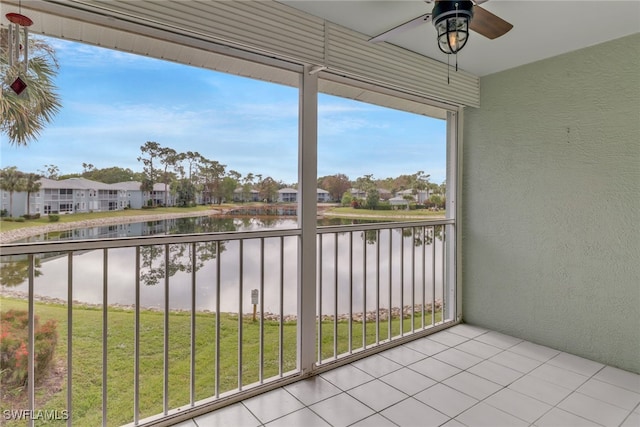 balcony with ceiling fan and a water view