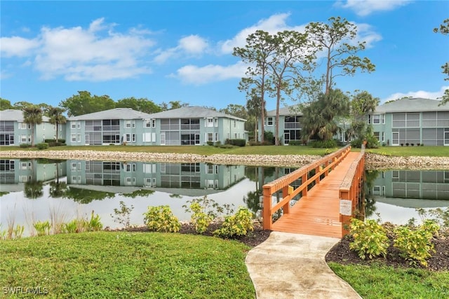 view of dock with a yard and a water view