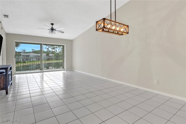 unfurnished living room with ceiling fan, a water view, light tile patterned flooring, and a textured ceiling