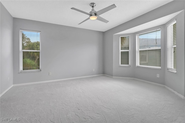 spare room featuring light carpet and ceiling fan