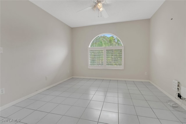 tiled spare room featuring ceiling fan