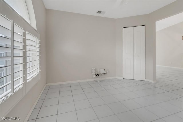 tiled empty room with a wealth of natural light