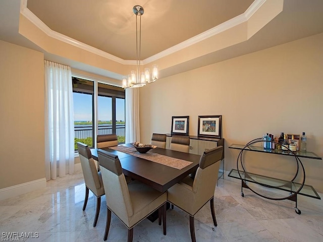 dining space with a tray ceiling, a water view, ornamental molding, and a notable chandelier