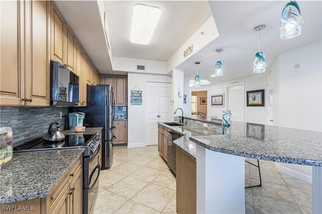 kitchen featuring tasteful backsplash, stainless steel appliances, sink, decorative light fixtures, and a breakfast bar area