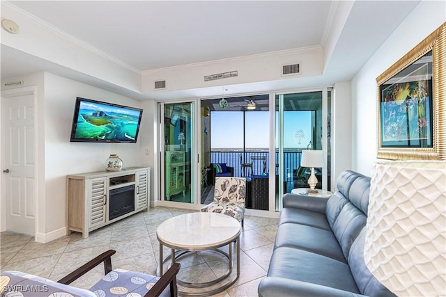 tiled living room with floor to ceiling windows, crown molding, and a tray ceiling