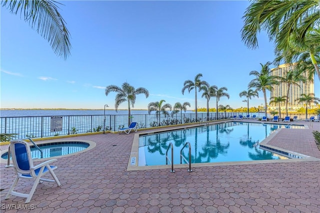 view of pool featuring a community hot tub and a water view