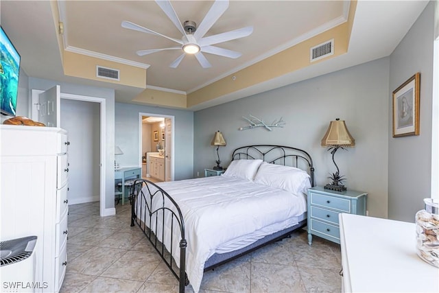 bedroom featuring a tray ceiling, ensuite bath, ceiling fan, and crown molding