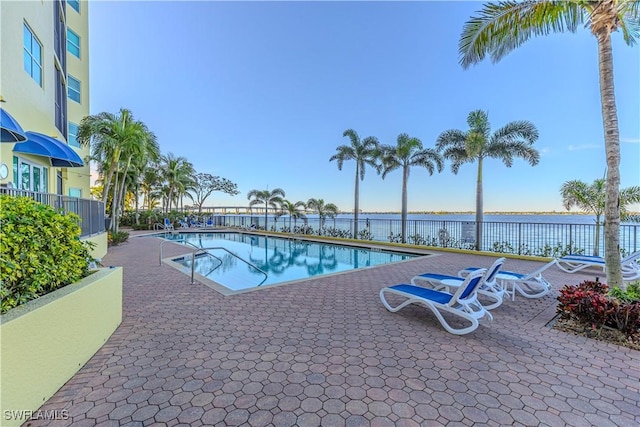 view of pool with a patio area and a water view