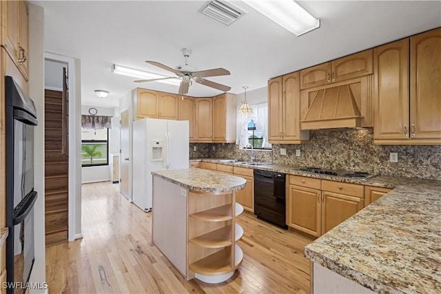 kitchen featuring light hardwood / wood-style flooring, a center island, black appliances, custom range hood, and decorative light fixtures