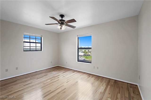 empty room with ceiling fan and light hardwood / wood-style flooring