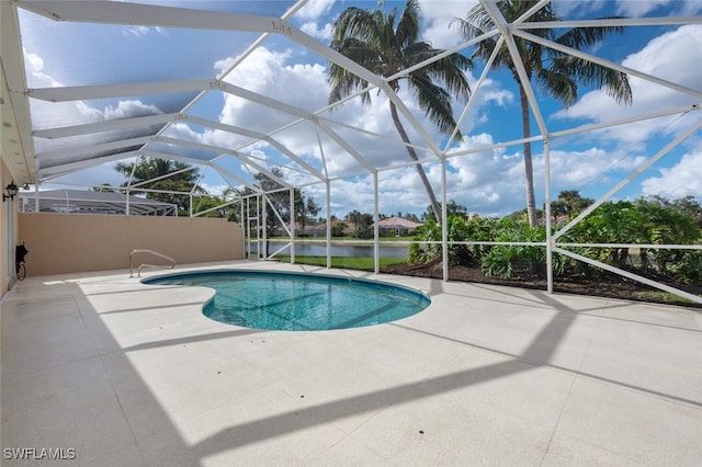 view of pool with a lanai, a patio area, and a water view