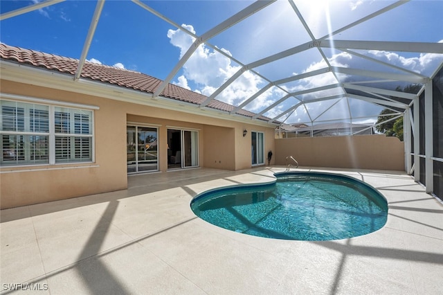 view of pool featuring glass enclosure and a patio