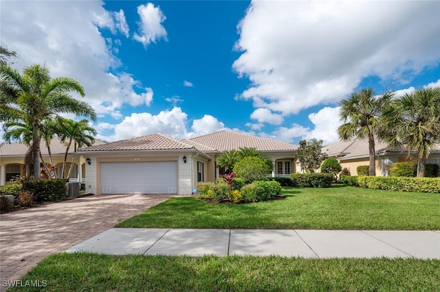 mediterranean / spanish-style house featuring central AC, a front yard, and a garage